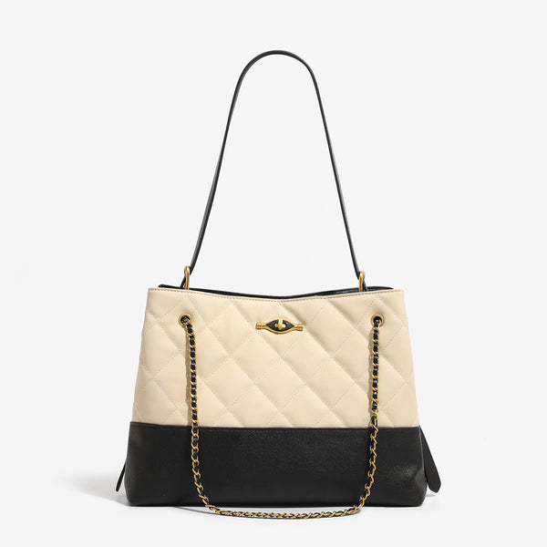 Large quilted two-tone shoulder tote bag with gold-tone chain handles and eye-shaped clasp hardware, detail view 6