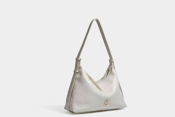 Übergroße, lässig fallende Hobo-Schultertasche aus glänzendem, geknittertem Lederimitat mit goldfarbenem Reißverschluss und Emblem-Beschlägen, Detailansicht