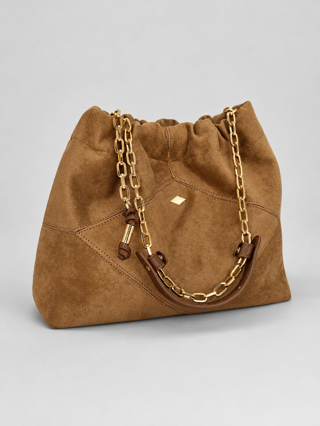 Slouchy suede-look shoulder bag with gathered top, angular stitched paneling, and chunky gold-tone chain strap, detail view