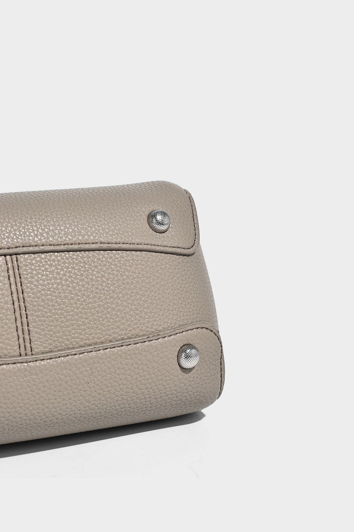 Structured pebbled leather-look tote bag with detachable scarf tie, dual top handles, and adjustable crossbody strap, detail