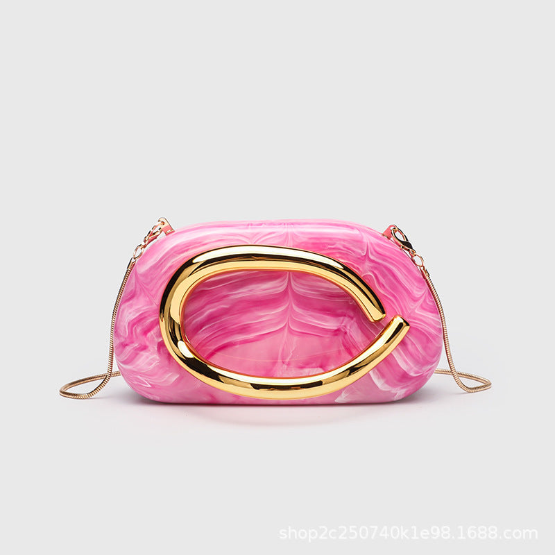 Kleine rechteckige Crossbody-Clutch mit abgerundeten Ecken, oversized poliertem C-förmigem Goldgriff und schmalem Goldkettenriemen, Detailansicht