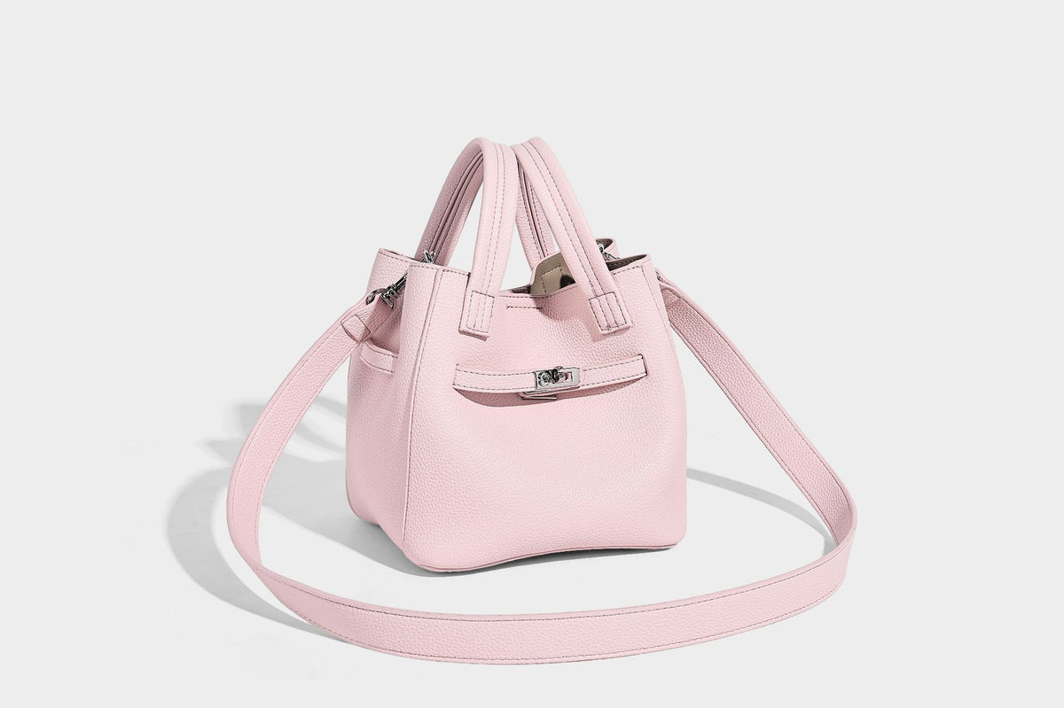 Small structured pebbled bucket tote bag with dual top handles, silver turn-lock front pocket, and detachable shoulder strap