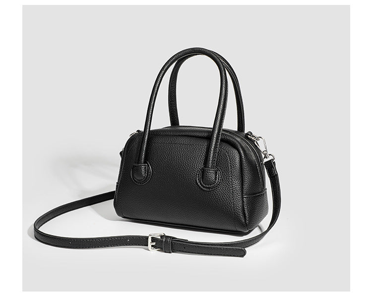 Mini-Boston-Tasche mit genarbtem Finish, zwei Henkeln, abnehmbarem und verstellbarem Crossbody-Riemen sowie silberfarbenen Beschlägen, Detailansicht
