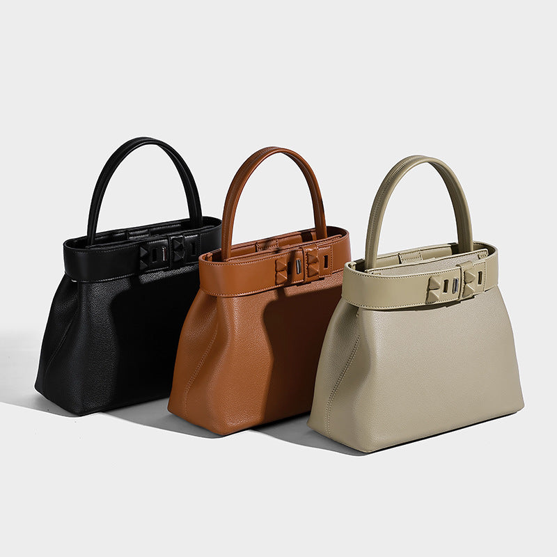 Structured trapezoid tote bag with belt-buckle top band, pebbled leather-look finish, and silver-tone hardware, detail view 2