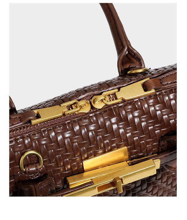 Structured woven-embossed leather-look satchel with dual rolled top handles, gold-tone turn-lock closure, and detachable