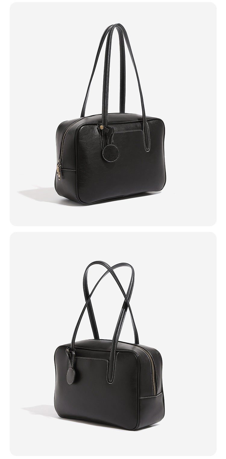 Structured boxy bowling-style tote bag in deep brown leather-look finish with dual top handles, front slip pocket, round