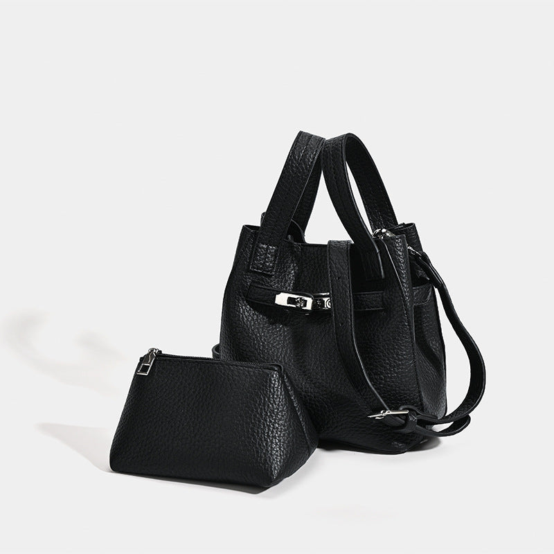 Small structured pebbled leather-look bucket bag with silver turn-lock bar hardware and dual top handles, detail view 3