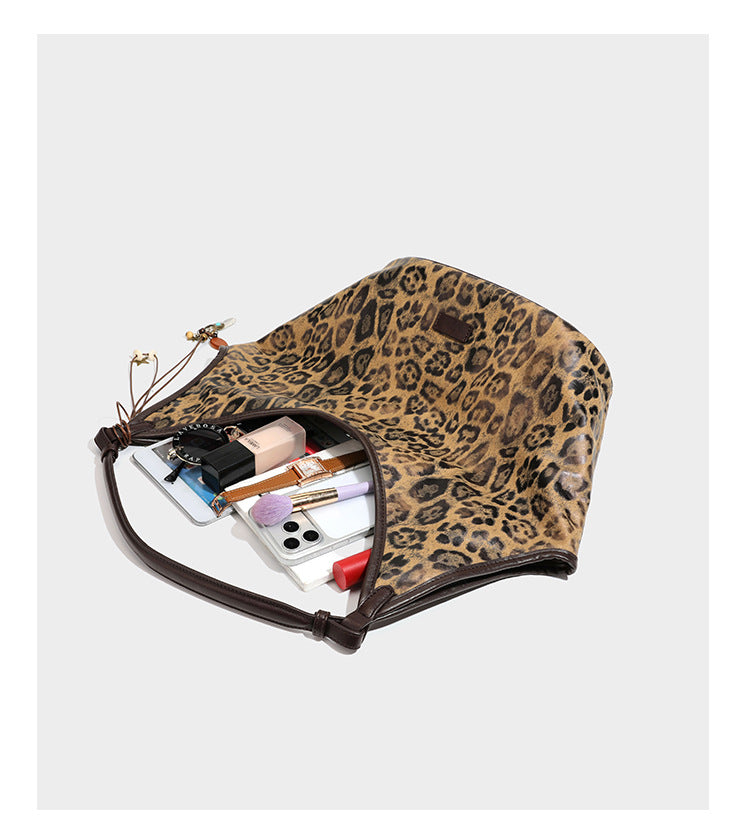 Large slouchy leopard-print shoulder tote bag with glossy tan-and-brown finish, dark brown leather-look trim, single