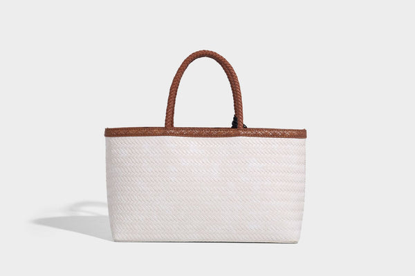 Structured woven-texture tote bag with brown braided top handles, decorative tassel charm, and detachable shoulder strap