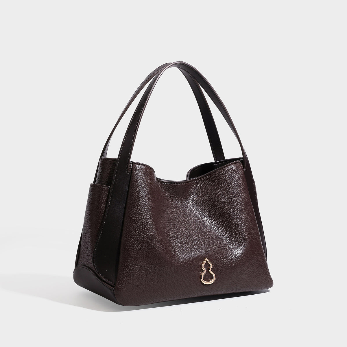 Schwarze Tote-Bag in genarbter Lederoptik mit kürbisförmigen Beschlägen in Goldoptik, zwei Tragegriffen und abnehmbarem Crossbody-Schulterriemen, Detailansicht