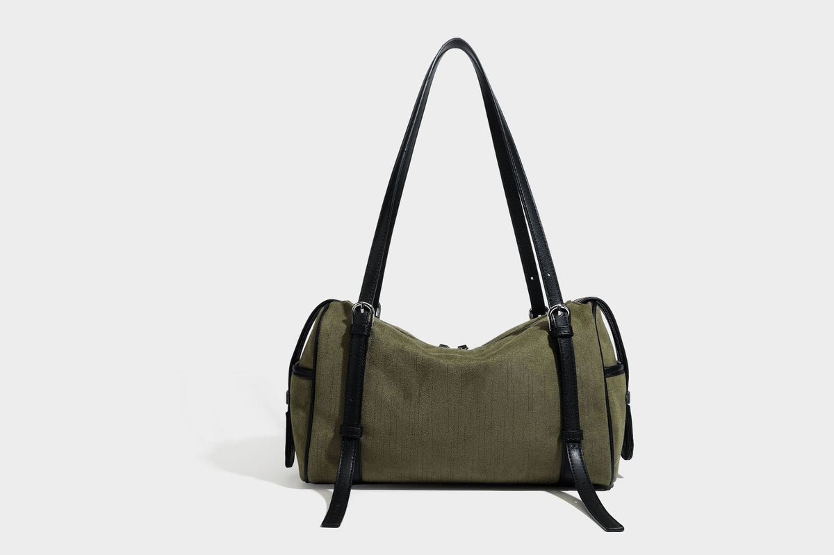 Olivgrüne Canvas-Schultertasche in Zylinderform mit schwarzen Trägern in Lederoptik, Reißverschluss oben und silberfarbenen Metallbeschlägen, Detailansicht