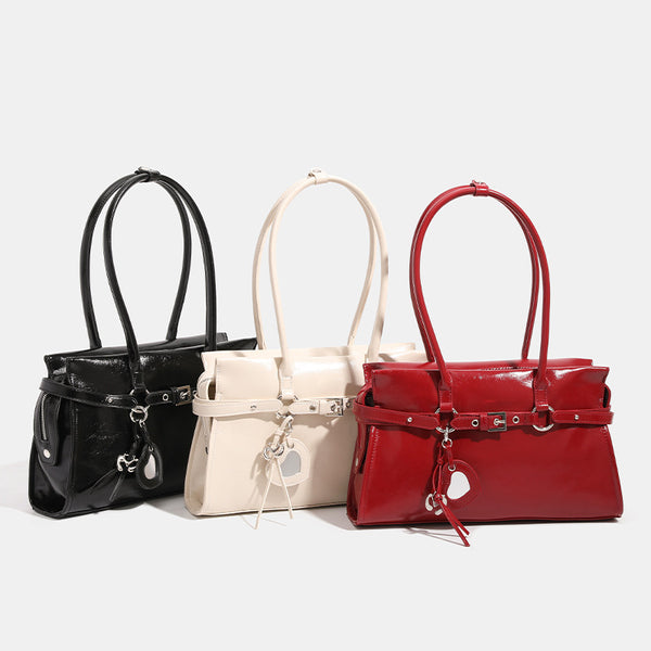 Strukturierte, glänzende Trapez-Schultertasche mit zwei Henkeln, umlaufendem Riemen, silberfarbener Schnalle und hängendem