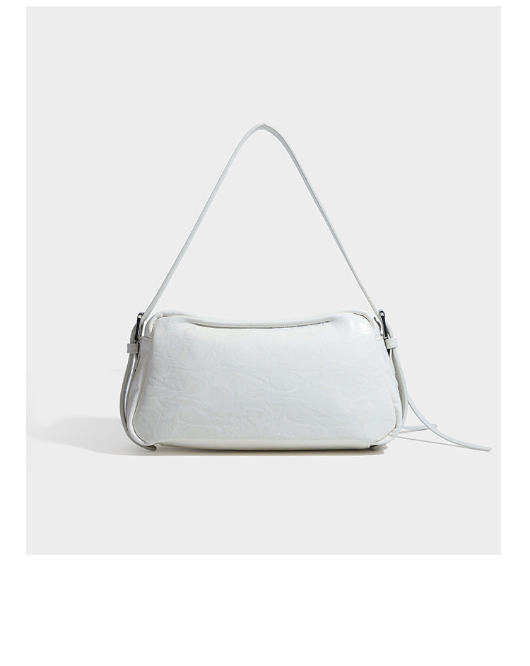 Compact black crinkled leather-look baguette shoulder bag with gold-tone arch hardware and adjustable strap, detail view 18