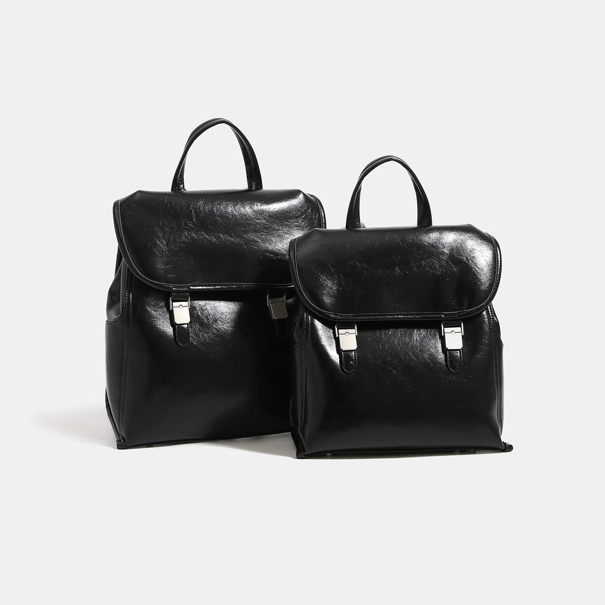Structured glossy leather-look flap backpack with twin buckle closures and top grab handle, detail view 3