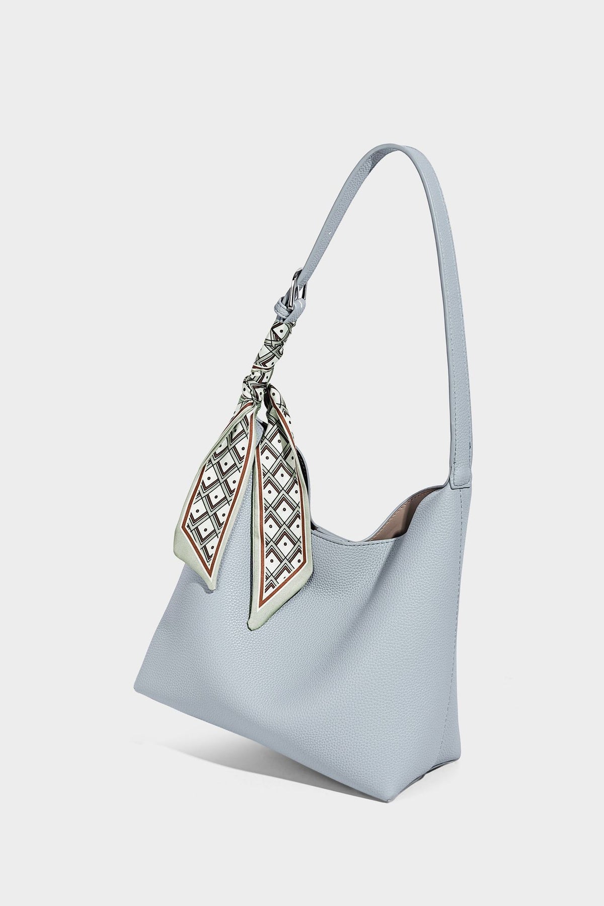Soft slouchy hobo shoulder bag in pebbled matte finish with slim strap, silver-tone ring hardware, and knotted printed scarf