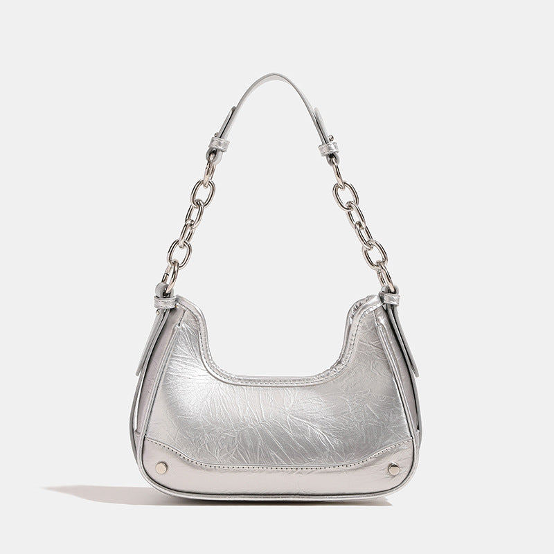 Compact crescent hobo shoulder bag in glossy burgundy leather-look finish with silver chain strap, red and green bead tassel