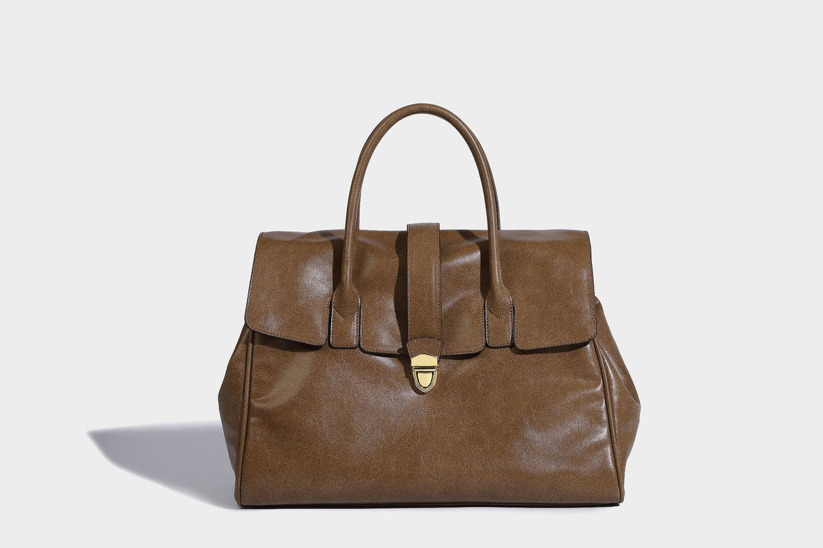 Strukturierte Henkeltasche in glänzender Lederoptik mit Überschlagverschluss, mittigem Riemen, goldfarbenem Drehverschluss und zwei Henkeln