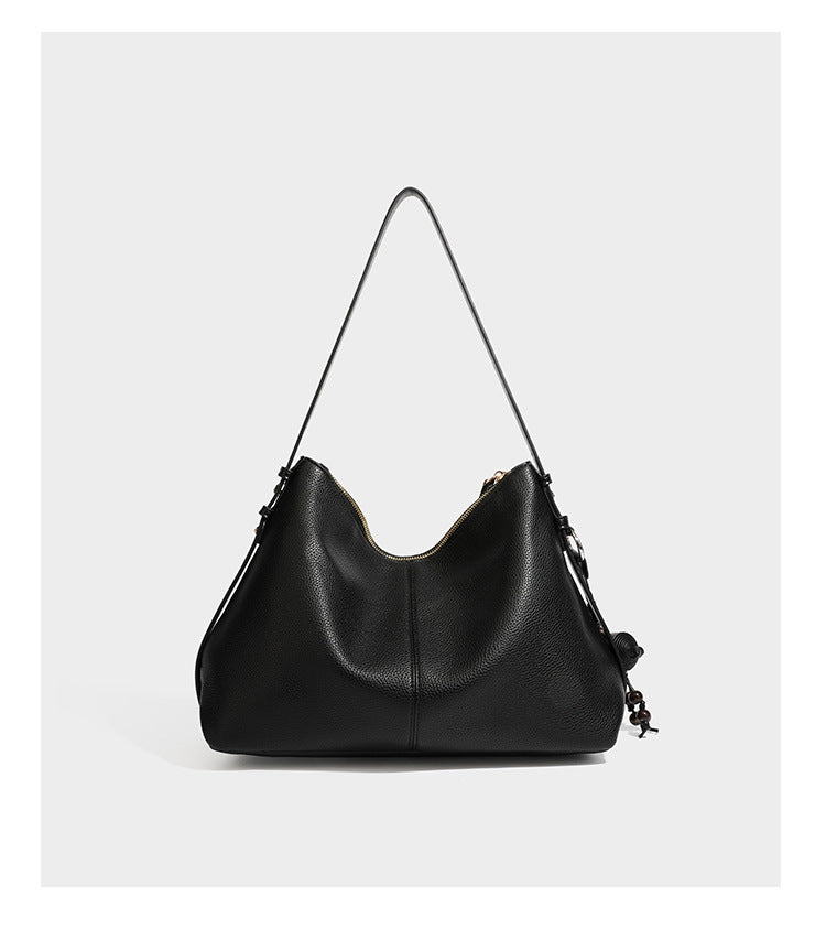 Slouchy hobo shoulder bag with pebbled leather-look finish, zip-top closure, gold-tone hardware, and hanging bead charm
