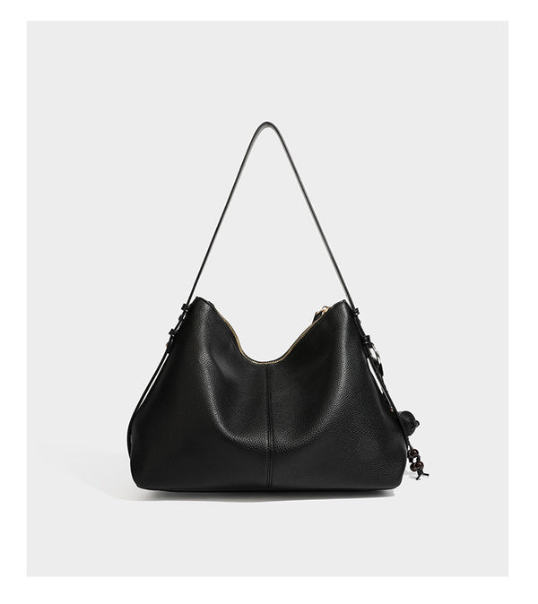 Slouchy hobo shoulder bag with pebbled leather-look finish, zip-top closure, gold-tone hardware, and hanging bead charm