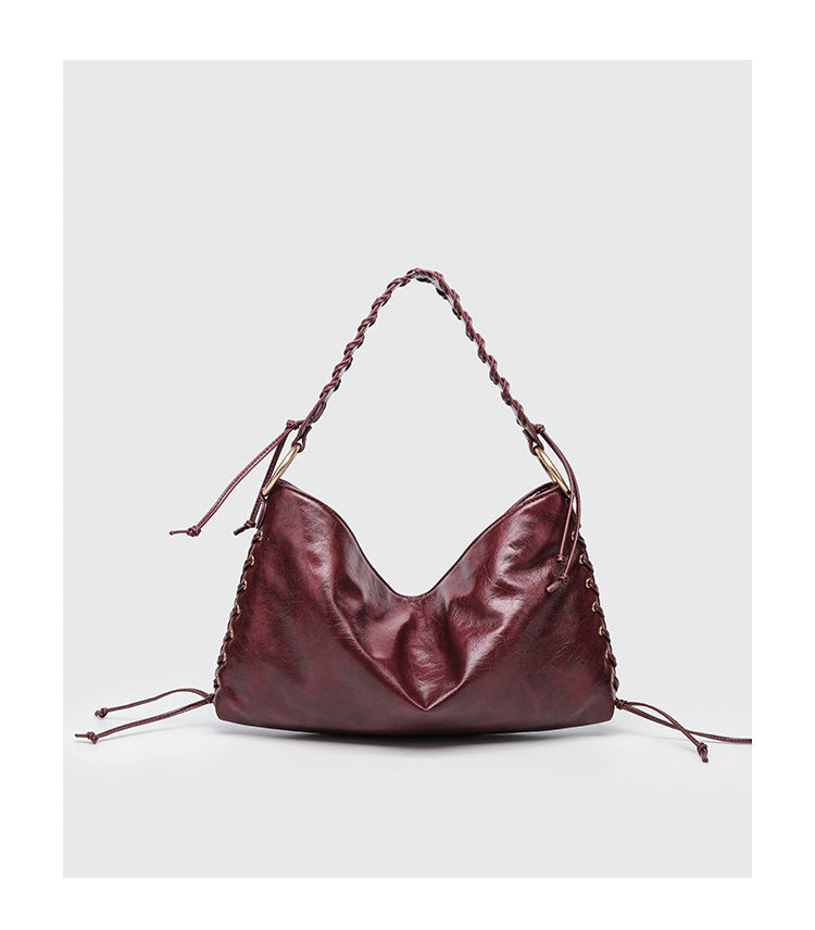 Large slouchy hobo shoulder bag with braided top handle, gold-tone O-ring hardware, and lace-up side cord detailing in