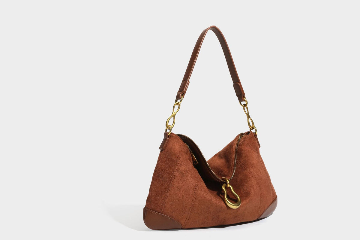 Slouchy denim shoulder bag with dark leather-look trim, gold-tone chain-link hardware, and top zipper closure, detail view 23