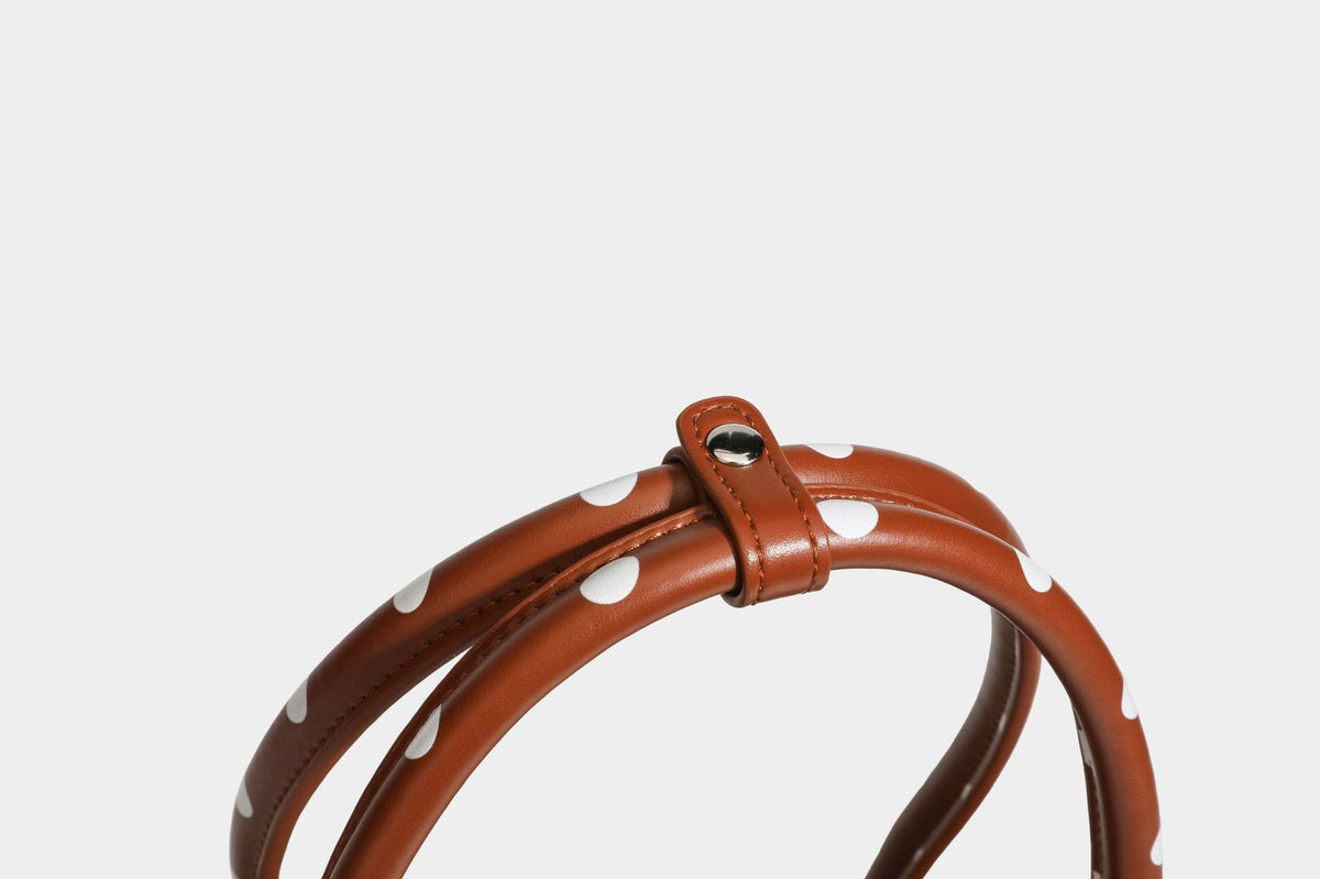 Strukturierte Baguette-Tasche mit Punktemuster in glänzender Lederoptik, zwei Tragegriffen, Überschlag mit Drehverschluss in Silberoptik und