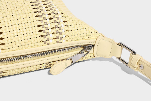 Small woven crescent shoulder bag with leather-look trim, zip closure, silver-tone ring hardware, and beaded tassel charm