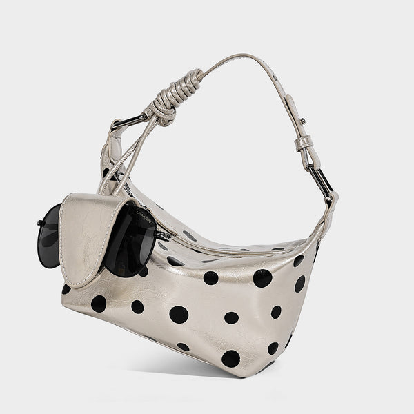 Schultertasche in glänzender Lederoptik mit Tupfenmuster, befestigtem Mini-Fronttäschchen, Reißverschluss oben und verstellbarem Riemen, Detailansicht