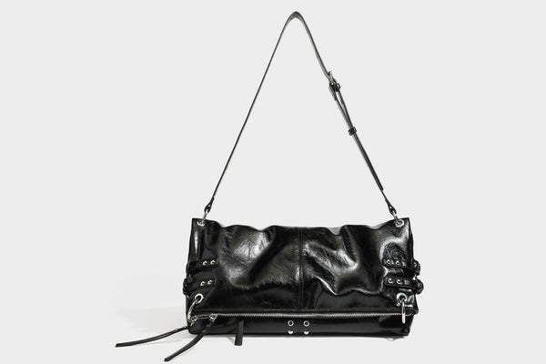 Black glossy leather-look slouchy shoulder bag with silver stud and eyelet hardware, top zip closure, front zip pocket, and