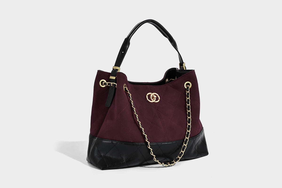 Gesteppte zweifarbige Schultertasche mit goldfarbener Kettenriemen und ineinandergreifendem Ringemblem im apricot-schwarzen Colorblock-Design, Detailansicht