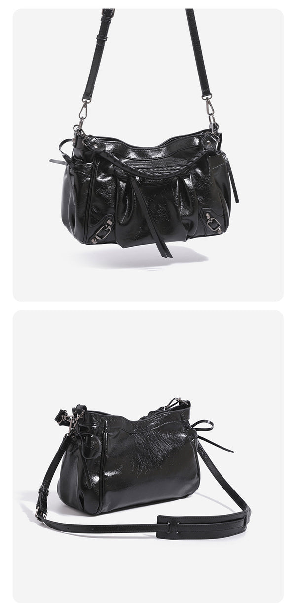 Glossy crinkled slouchy shoulder bag with silver-tone studs, fringe tassel pulls, front zip pocket, and arched top handle