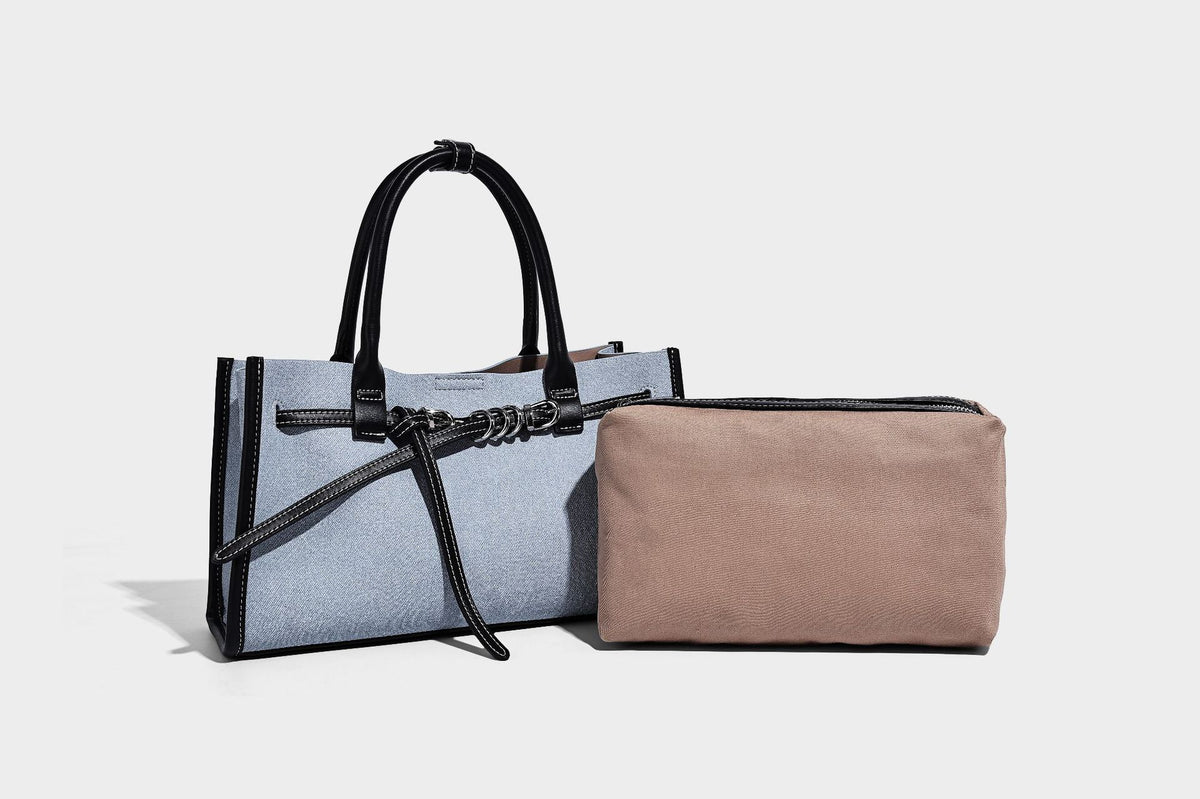 Structured rectangular tote satchel in denim-look fabric with dark trim, knotted front strap hardware, and detachable, detail