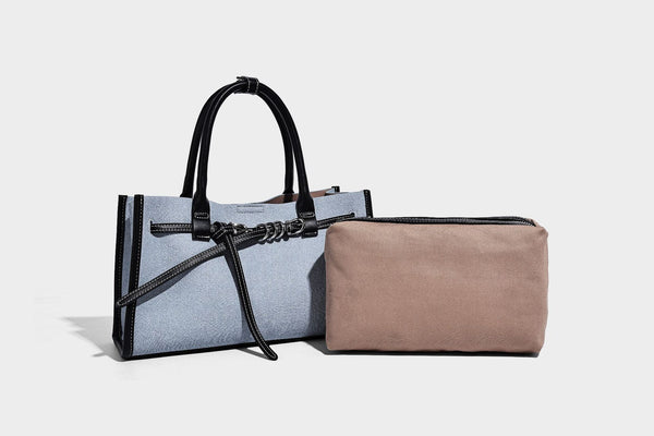 Structured rectangular tote satchel in denim-look fabric with dark trim, knotted front strap hardware, and detachable, detail