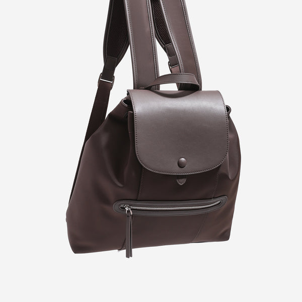 Large flap-top nylon backpack with leather-look trim, snap closure, front zip pocket, and padded shoulder straps, detail view