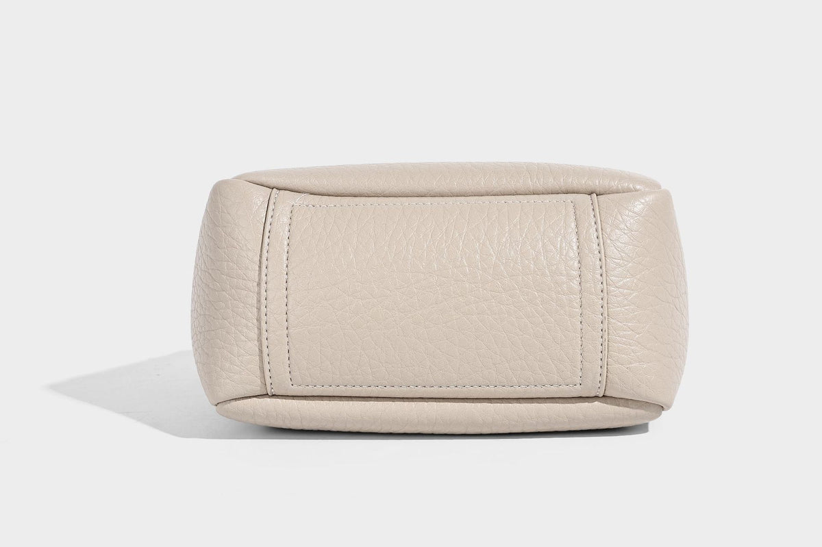 Small structured pebbled bucket tote with double top handles, silver turn-lock hardware, and detachable shoulder strap