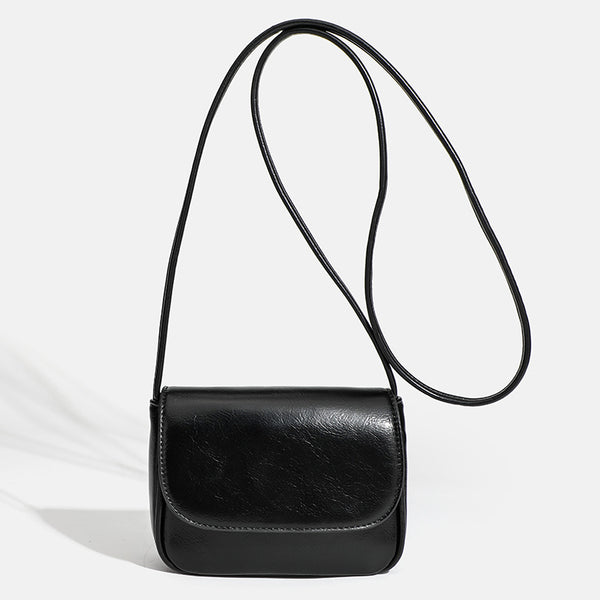 Compact rounded rectangular flap crossbody bag with glossy leather-look finish and long shoulder strap, detail view 7