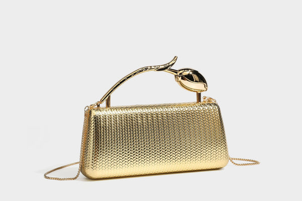 Structured rectangular metallic woven clutch bag with sculptural gold-tone leaf top handle and detachable chain strap, detail