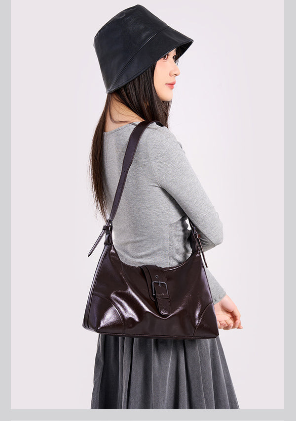 Glossy dark brown slouch hobo shoulder bag with front buckle strap panel and long adjustable single strap, detail view 9