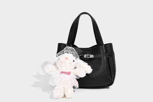 Small structured pebbled bucket tote with double top handles, silver turn-lock hardware, and detachable shoulder strap