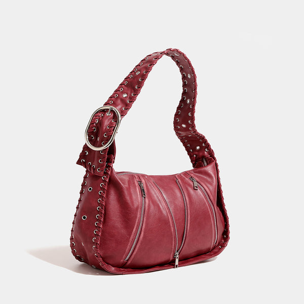 Slouchy hobo shoulder bag with wide braided eyelet strap, multiple front zip compartments, and silver-tone ring buckle