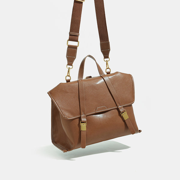 Structured flap-over backpack satchel in smooth leather-look finish with gold-tone buckle hardware and top handle, front view