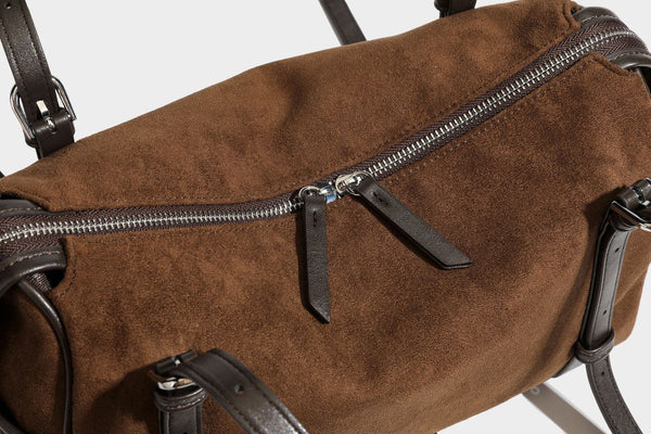 Large brown suede-finish barrel shoulder bag with dark leather-look trim, silver-tone zippers, dual top handles, and long