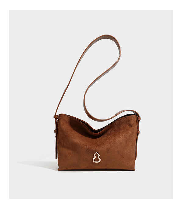 Slouchy suede-finish brown shoulder bag with long single strap and small gold-tone logo emblem on front, detail view 14