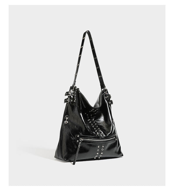 Black glossy leather-look slouchy shoulder bag with silver stud and eyelet hardware, top zip closure, front zip pocket, and