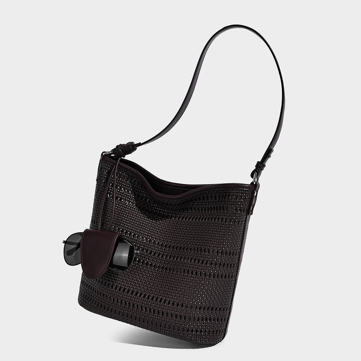 Handwoven open-weave shoulder bag with leather-look trim, knotted adjustable strap, and clip-on sunglasses sleeve pouch