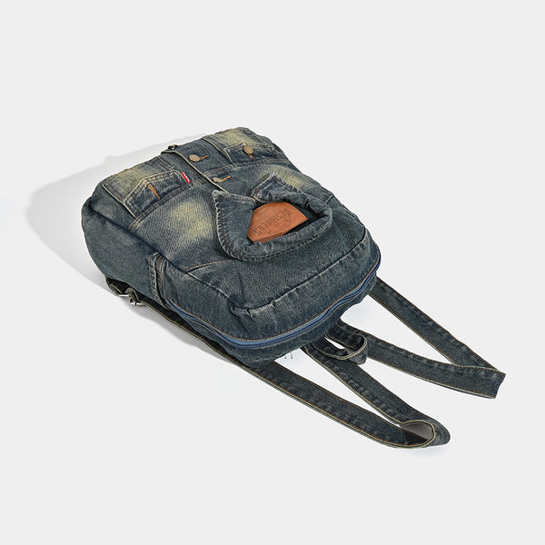 Vintage wash dark indigo denim backpack with jacket collar detail, snap buttons, patch pockets, and leather-look label