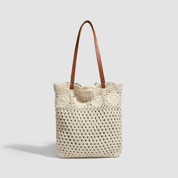 Woven crochet shoulder tote bag with scalloped floral top edge, tan leather-look straps, and antique gold rivets, front view