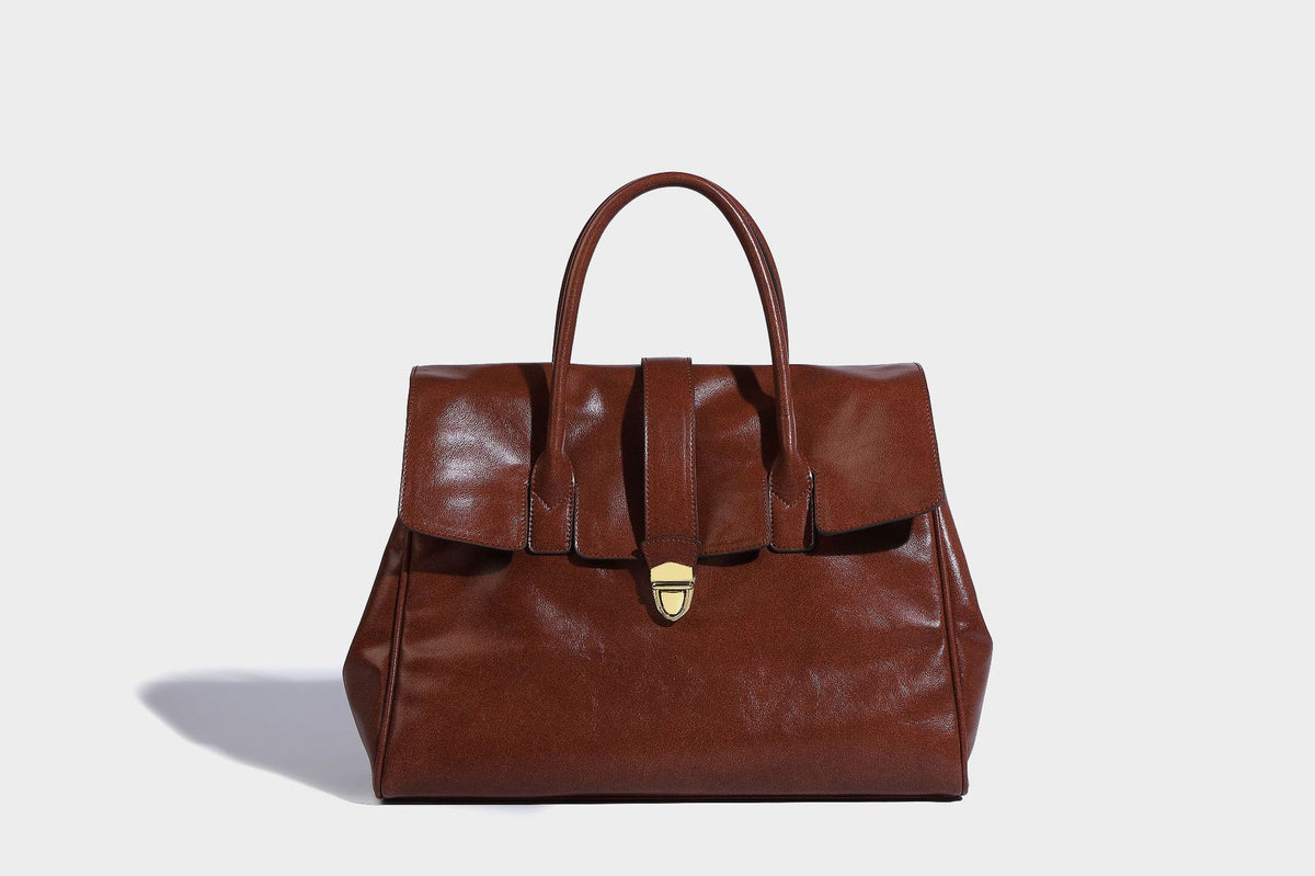 Strukturierte Henkeltasche in glänzender Lederoptik mit Überschlagverschluss, mittigem Riemen, goldfarbenem Drehverschluss und zwei Henkeln