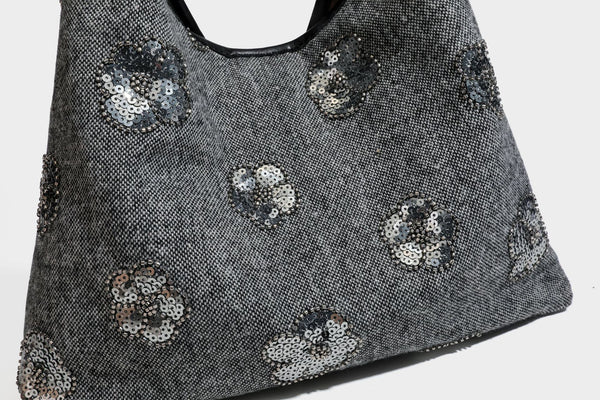 Lässig fallende, trapezförmige Schulter-Tote in Anthrazitgrau mit floralen Paillettenmotiven in Silber, Riemen in Lederoptik und herabhängendem Perlenbesatz