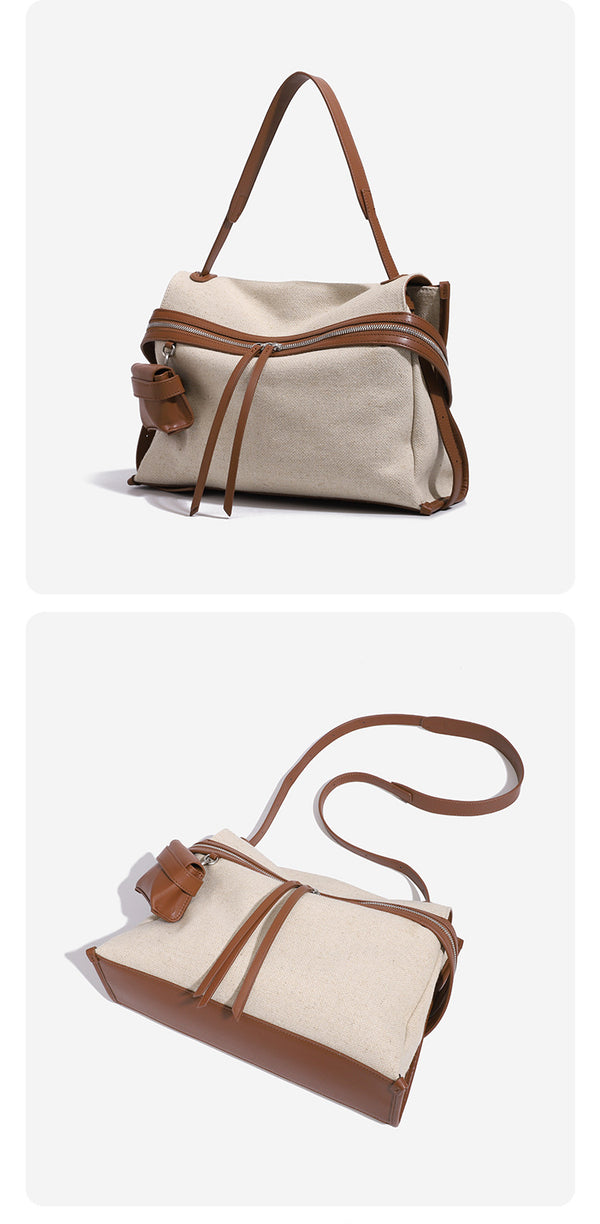 Cream canvas zip-top shoulder bag with cognac leather-look trim, dual zipper, attached mini pouch, and tassel strap ties
